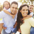 Parents Giving Children Piggyback Ride In Garden